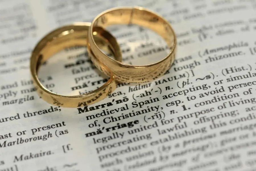 Two wedding rings resting on an open Bible