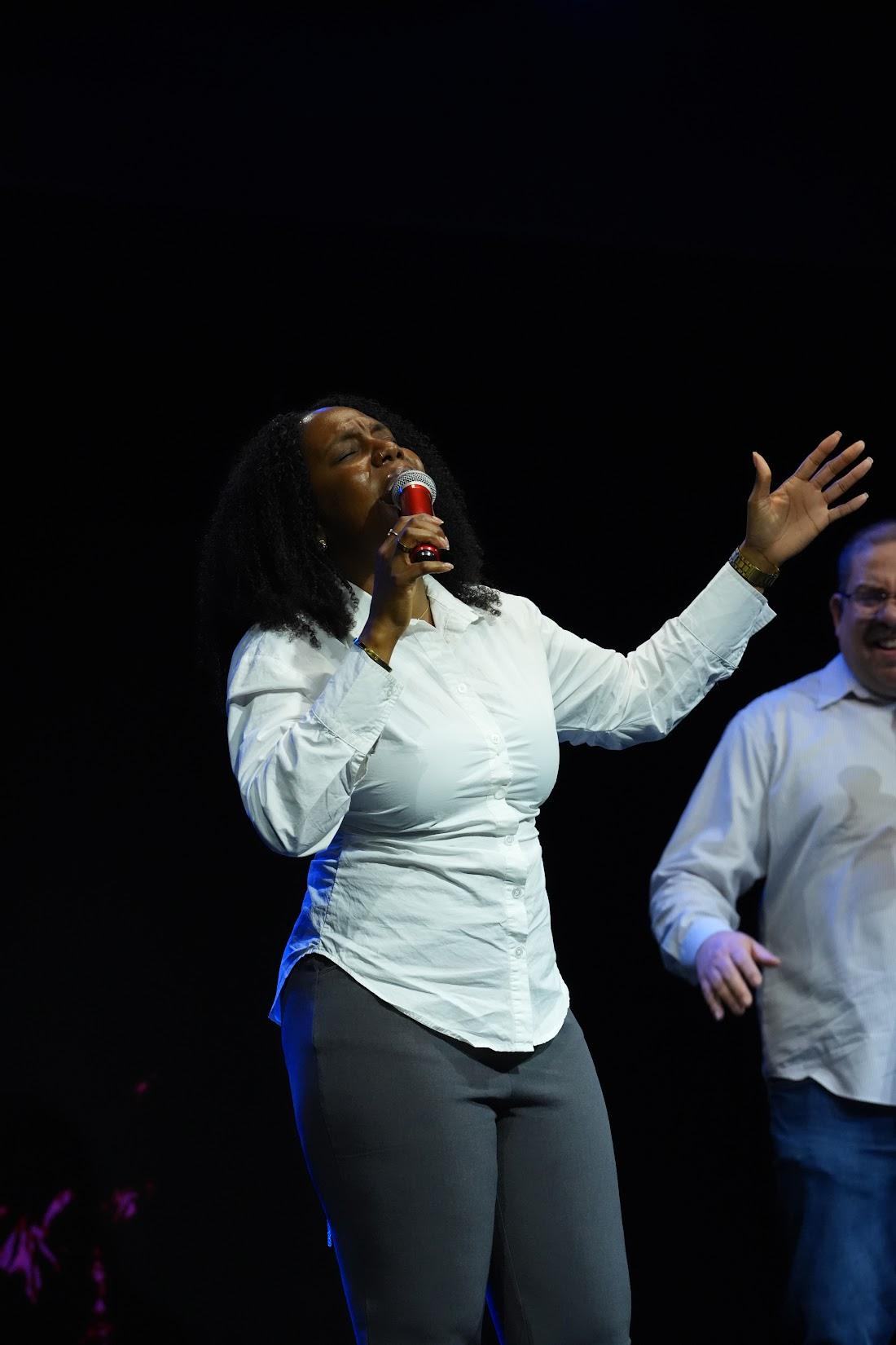 A Grace Place worship leader singing on stage